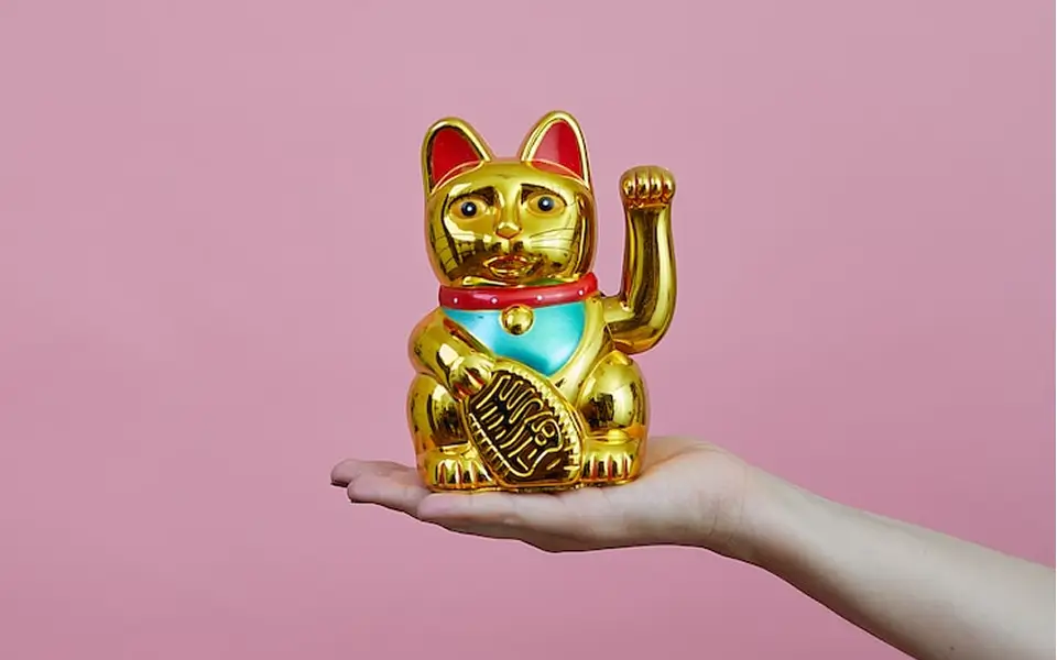 手の上に金色の招き猫をのせた写真
