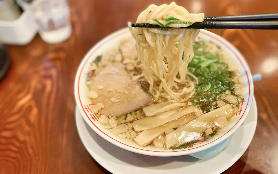 尾道ラーメンの麺を箸で持ち上げている写真