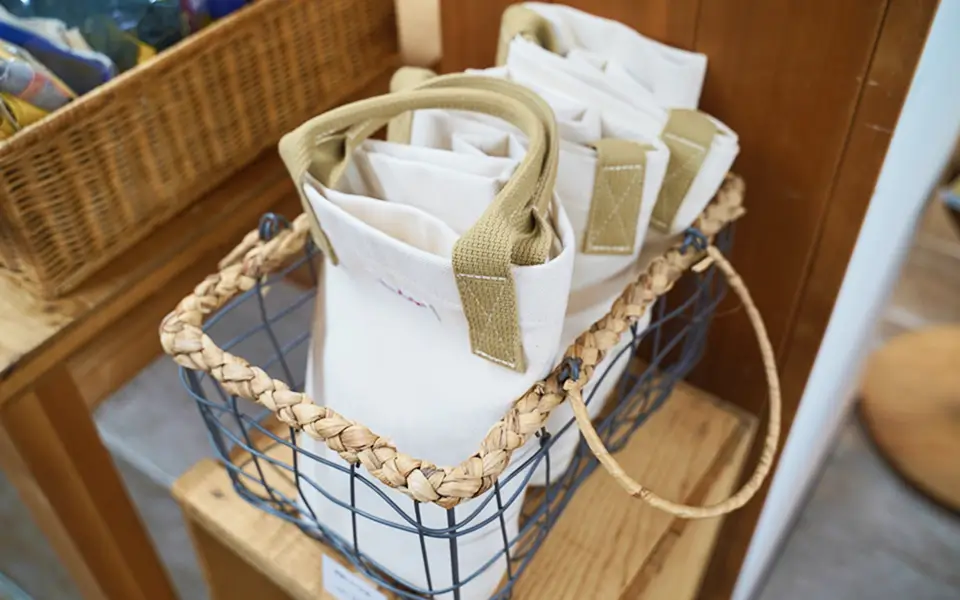 ベージュの持ち手がついた白い帆布バッグがカゴに入っている写真